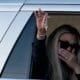 Erika Kirk waves to supporters holding Charlie Kirk’s cross necklace, a symbol of his faith and enduring legacy.